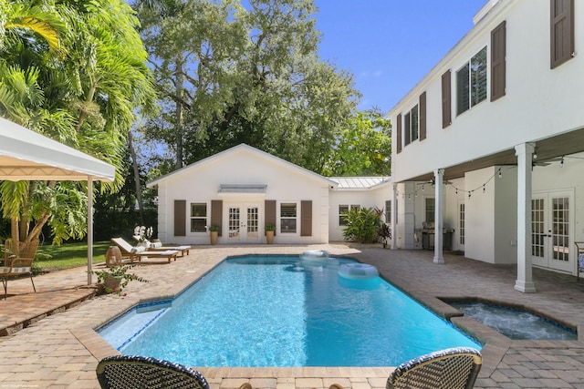 view of swimming pool featuring an in ground hot tub, a patio, and french doors