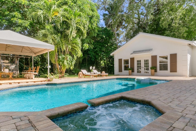 view of swimming pool featuring french doors, a gazebo, an in ground hot tub, an outdoor structure, and a patio