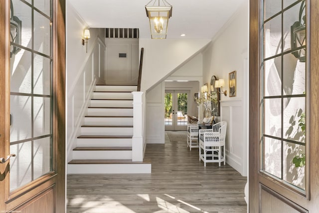 entryway featuring ornamental molding, dark wood-type flooring, and french doors