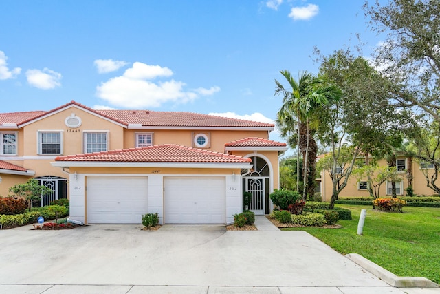 mediterranean / spanish house featuring a front lawn and a garage