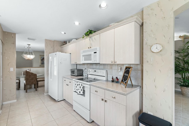 kitchen with backsplash, light tile patterned floors, pendant lighting, and white appliances