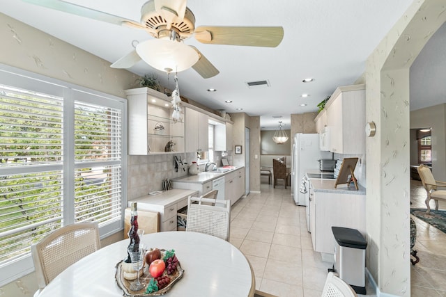 tiled dining space with ceiling fan and sink