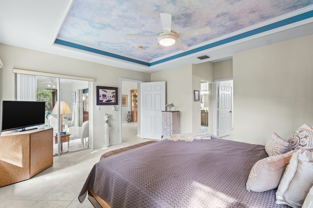 bedroom featuring a raised ceiling, ceiling fan, light tile patterned floors, and ornamental molding