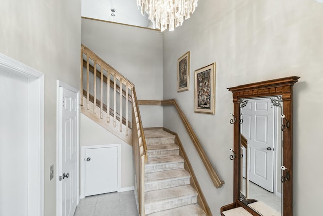 stairway featuring a towering ceiling and a notable chandelier