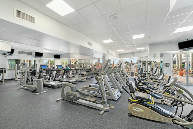 gym with a paneled ceiling and a wealth of natural light