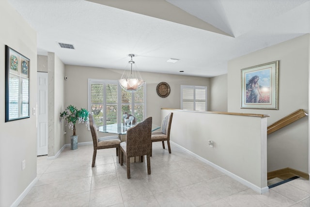 tiled dining room with a notable chandelier