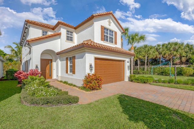 mediterranean / spanish house featuring a front lawn and a garage