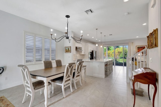 dining area with a chandelier and light tile patterned floors