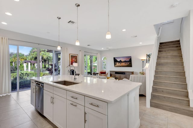 kitchen with a kitchen island with sink, sink, dishwasher, and hanging light fixtures