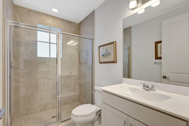 bathroom with an enclosed shower, vanity, and toilet