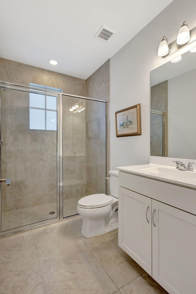 bathroom with tile patterned flooring, vanity, a shower with shower door, and toilet