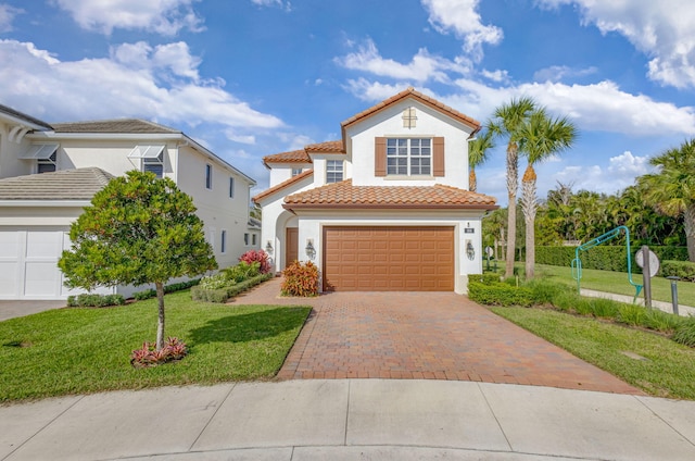 mediterranean / spanish-style house featuring a front yard and a garage