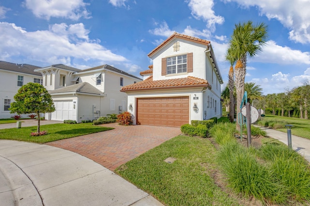 mediterranean / spanish house featuring a front lawn and a garage