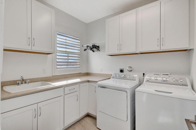 laundry area featuring washer and clothes dryer, sink, and cabinets