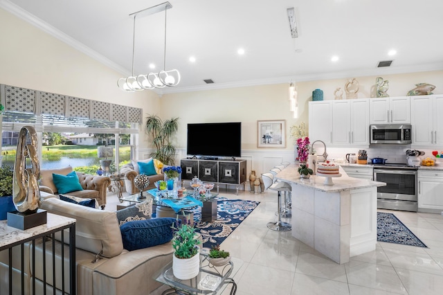 living room featuring light tile patterned floors, a chandelier, and ornamental molding