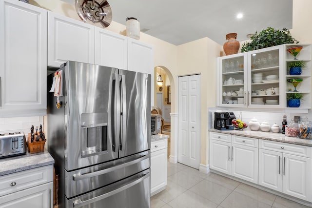 kitchen with stainless steel fridge with ice dispenser, tasteful backsplash, and white cabinetry