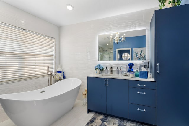 bathroom featuring vanity, a bath, tile walls, a notable chandelier, and tile patterned flooring