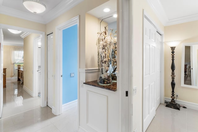 hall featuring crown molding and light tile patterned floors