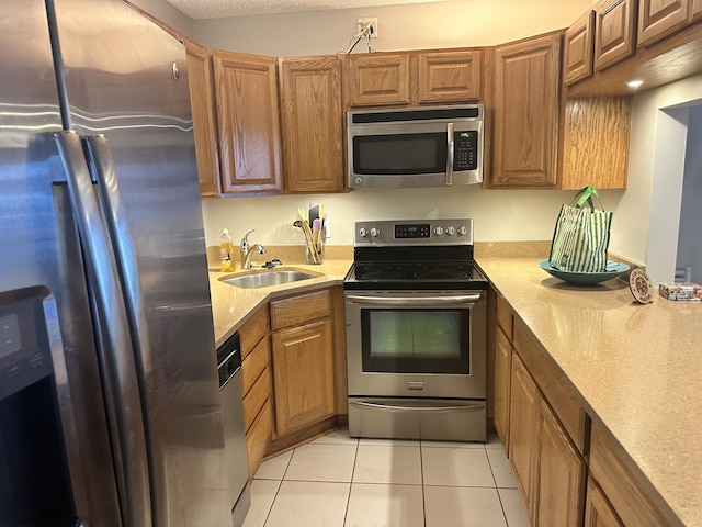 kitchen featuring light tile patterned floors, stainless steel appliances, and sink