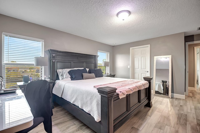 bedroom featuring light wood-type flooring and a textured ceiling