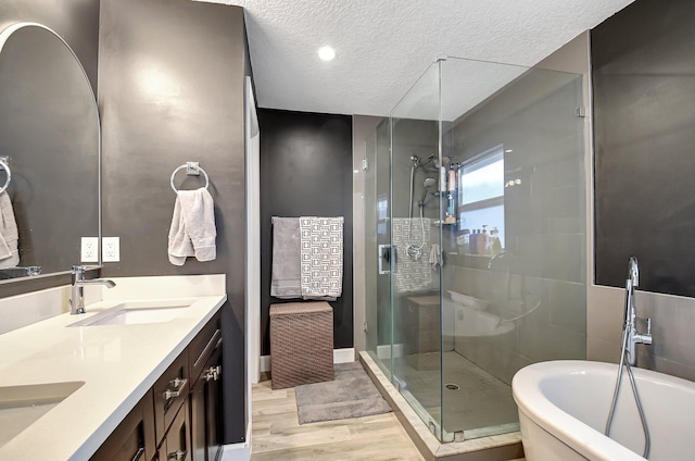 bathroom featuring separate shower and tub, vanity, a textured ceiling, and hardwood / wood-style flooring