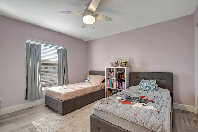 bedroom with light hardwood / wood-style flooring and ceiling fan