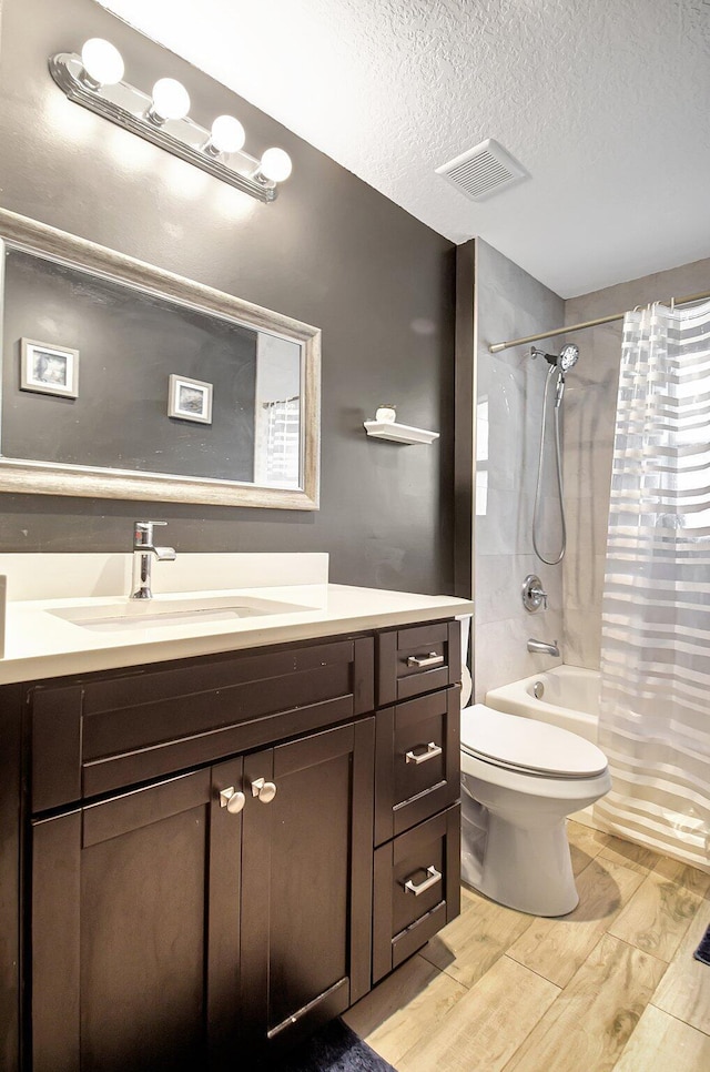 full bathroom featuring vanity, shower / bathtub combination with curtain, a textured ceiling, and toilet