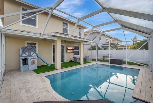 view of swimming pool with outdoor lounge area, glass enclosure, and a patio