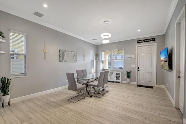 dining area with crown molding and light wood-type flooring