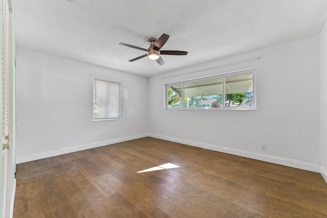 spare room featuring ceiling fan and dark wood-type flooring