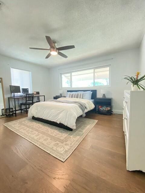 bedroom featuring ceiling fan, light hardwood / wood-style floors, and a textured ceiling