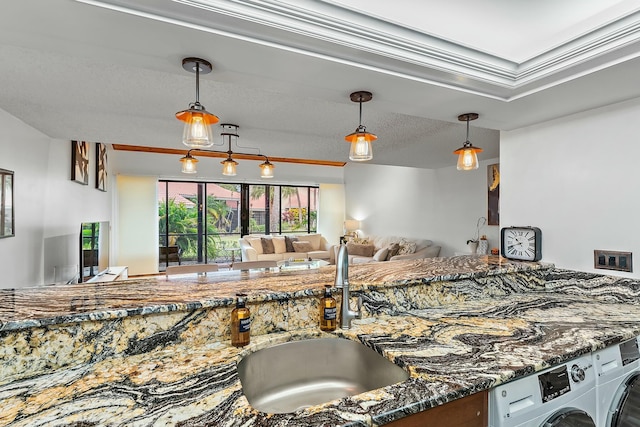 kitchen with sink, decorative light fixtures, a textured ceiling, dark stone countertops, and crown molding