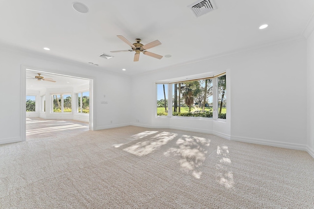 carpeted spare room featuring ceiling fan and ornamental molding