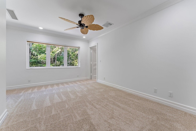 carpeted spare room featuring ceiling fan and ornamental molding