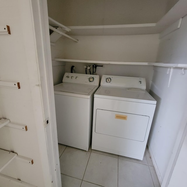 laundry room with light tile patterned floors and washing machine and clothes dryer