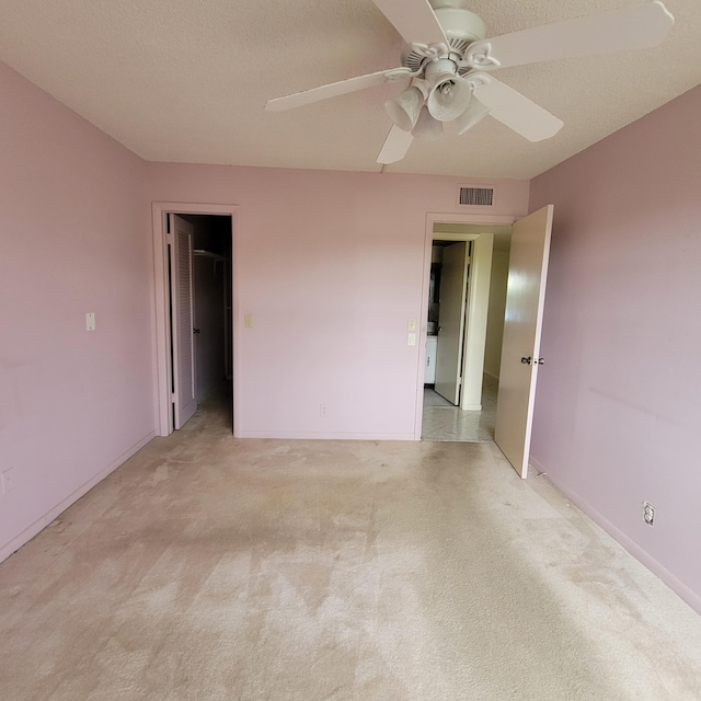 empty room featuring ceiling fan and light carpet