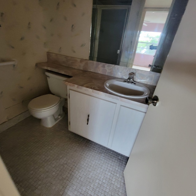 bathroom featuring tile patterned flooring, vanity, and toilet