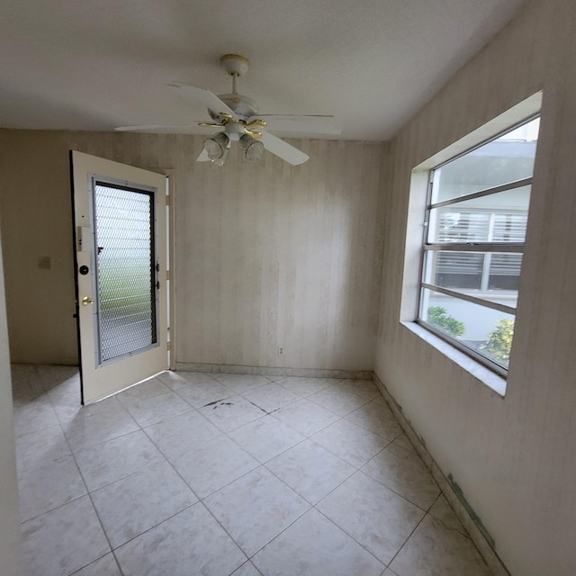 tiled spare room featuring ceiling fan