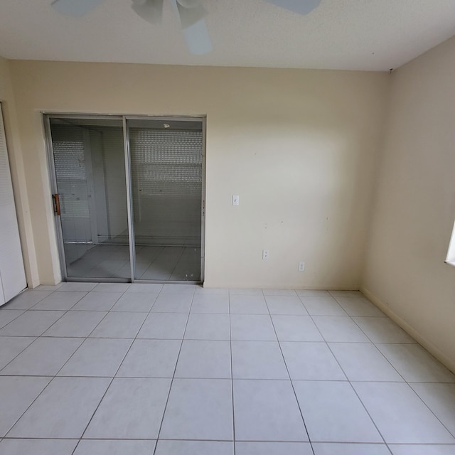 unfurnished bedroom with ceiling fan, light tile patterned floors, and a closet