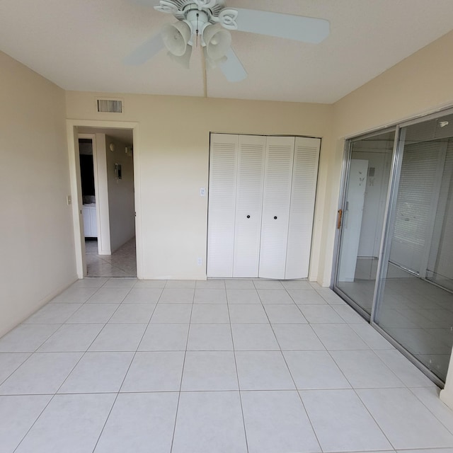 unfurnished bedroom featuring ceiling fan, a closet, and light tile patterned flooring