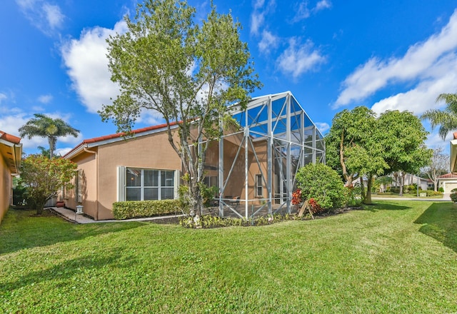 rear view of property featuring a yard and a lanai