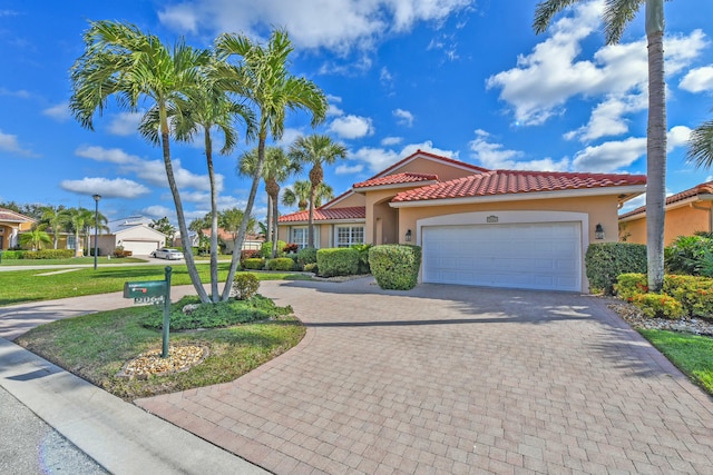 mediterranean / spanish-style house featuring a front yard and a garage