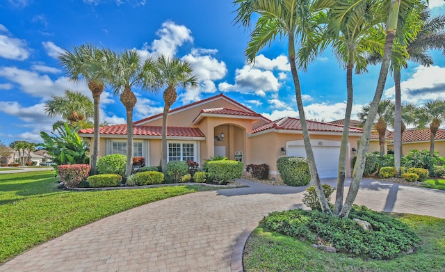 mediterranean / spanish home with a garage and a front lawn