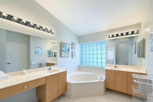 bathroom featuring tile patterned floors, a washtub, vanity, and lofted ceiling