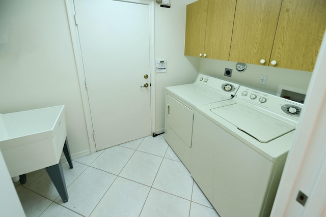 laundry room featuring cabinets, separate washer and dryer, and light tile patterned flooring