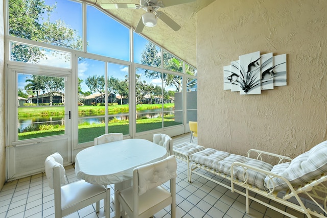 sunroom / solarium with ceiling fan, a water view, and vaulted ceiling