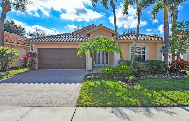 mediterranean / spanish-style home featuring a front yard and a garage