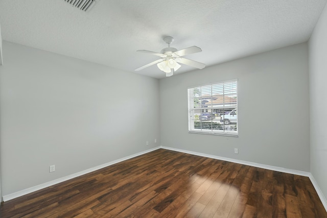 unfurnished room with ceiling fan, dark wood-type flooring, and a textured ceiling