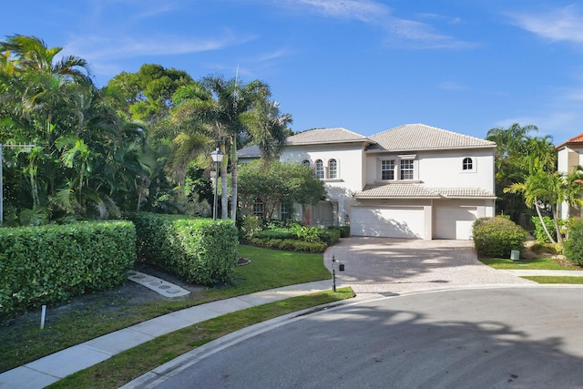 mediterranean / spanish-style house with a front yard and a garage