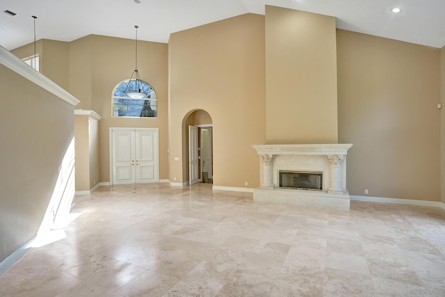 unfurnished living room with a fireplace and a high ceiling